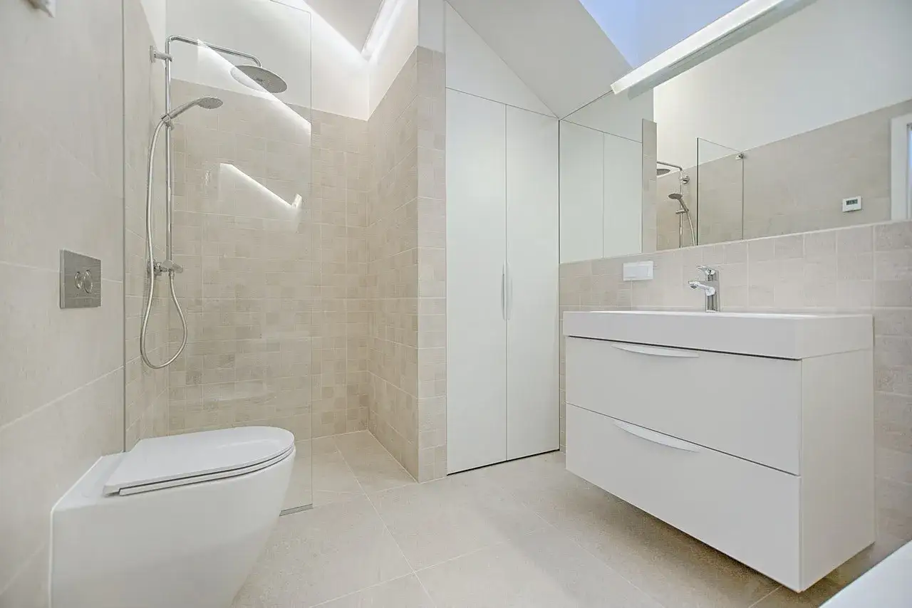 Modernos baños reformados con plato de ducha, inodoro suspendido y mueble de lavabo flotante.