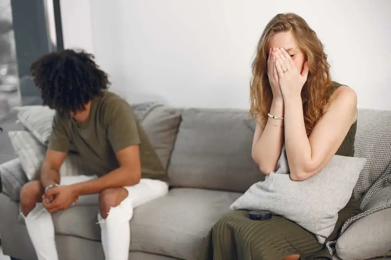 Pareja en sof&aacute;, ella oculta su rostro, &eacute;l de espaldas. &iquest;Filofobia? Excusas para no avanzar.