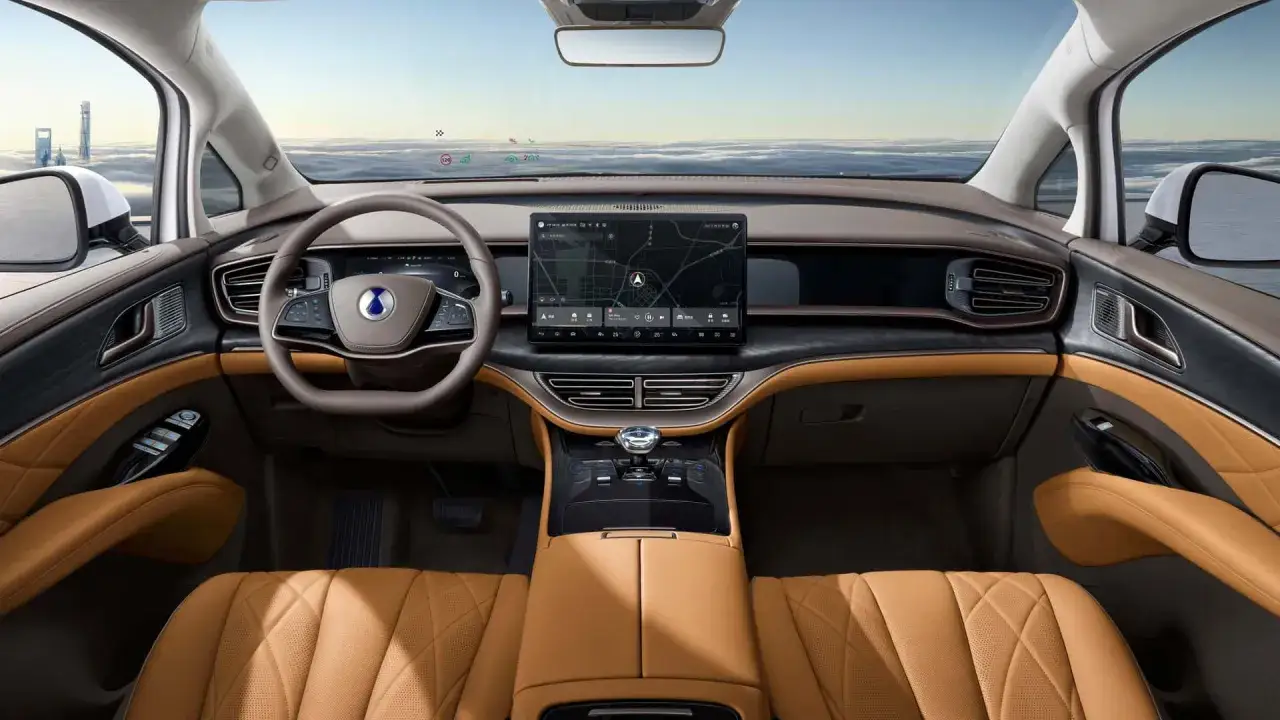 Interno lussuoso di un'auto con sedili in pelle color caramello, volante moderno e grande schermo centrale. Il **denza d9** offre un'esperienza di guida futuristica.