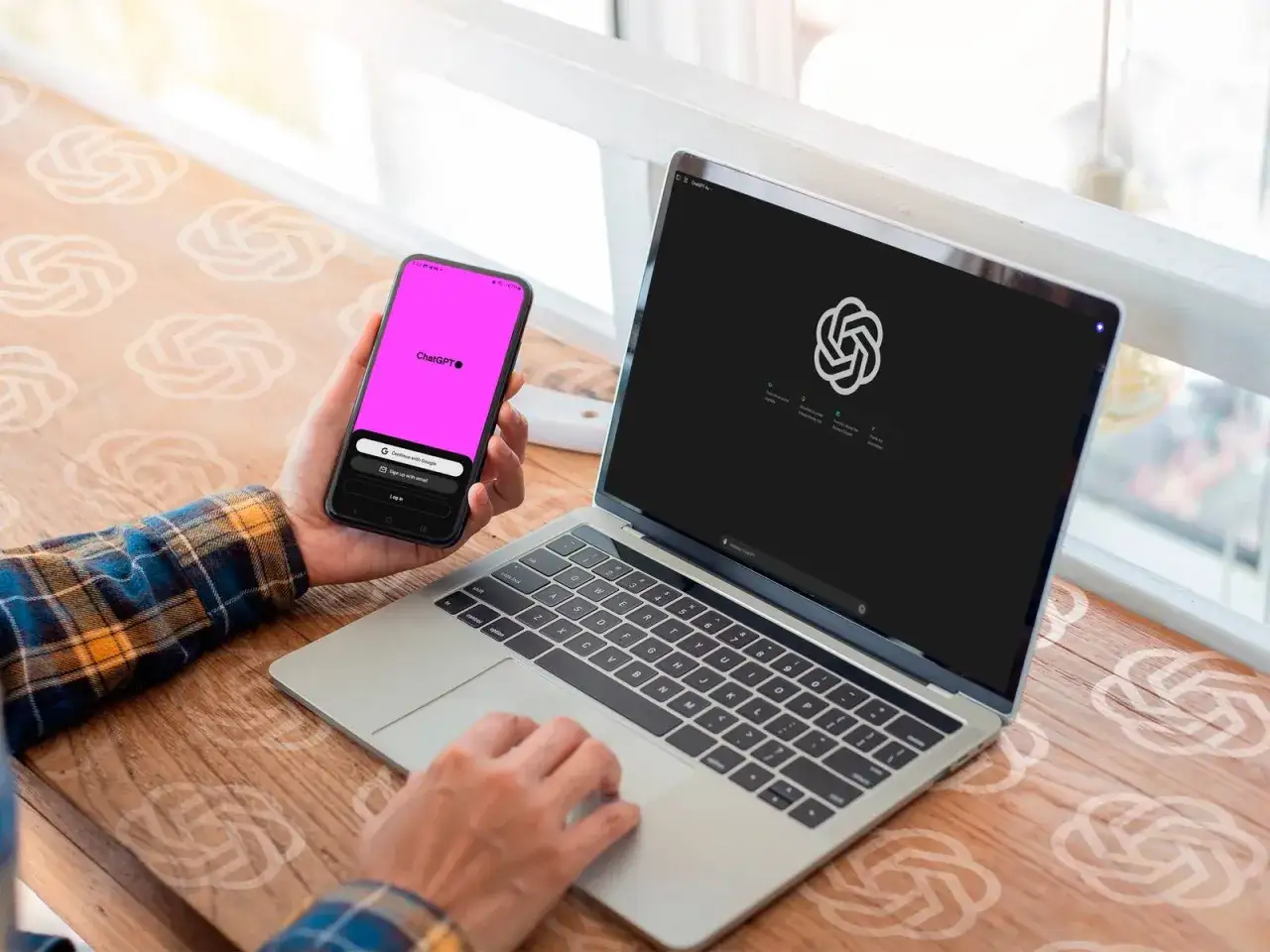 Osoba korzysta z telefonu z aplikacją ChatGPT i laptopa z logo ChatGPT. To idealny zestaw do pracy z chat gpt pro.