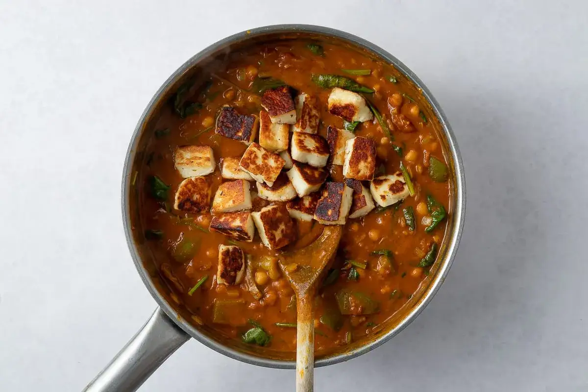 En gryta med palak paneer och halloumi, en smakrik indisk rätt med spenat, kikärtor och stekt halloumi.