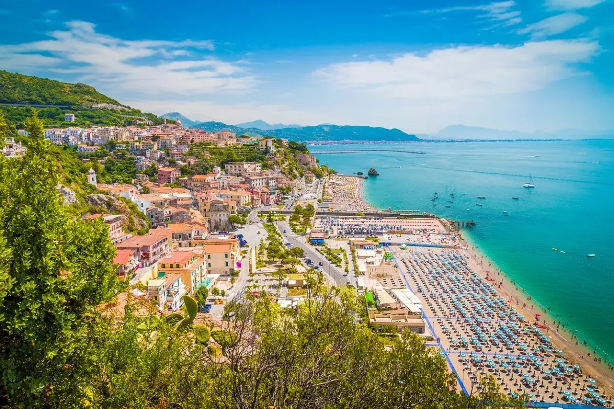 Vista panoramica delle spiagge di Vietri sul Mare, con case colorate aggrappate alla collina e un mare azzurro scintillante.