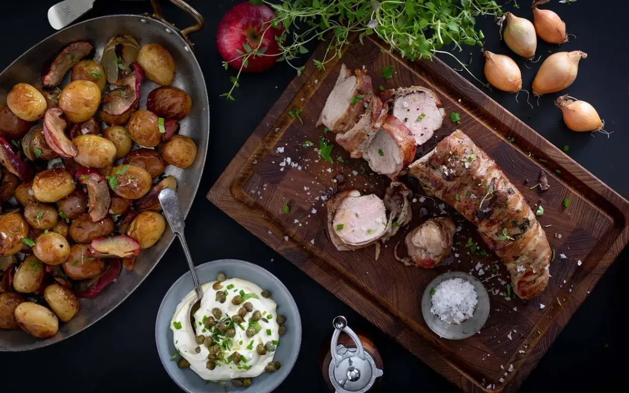 En saftig ytterfile i ugn, insvept i bacon, serveras med ugnsrostade sm&aring;potatisar och en kr&auml;mig s&aring;s med kapris.
