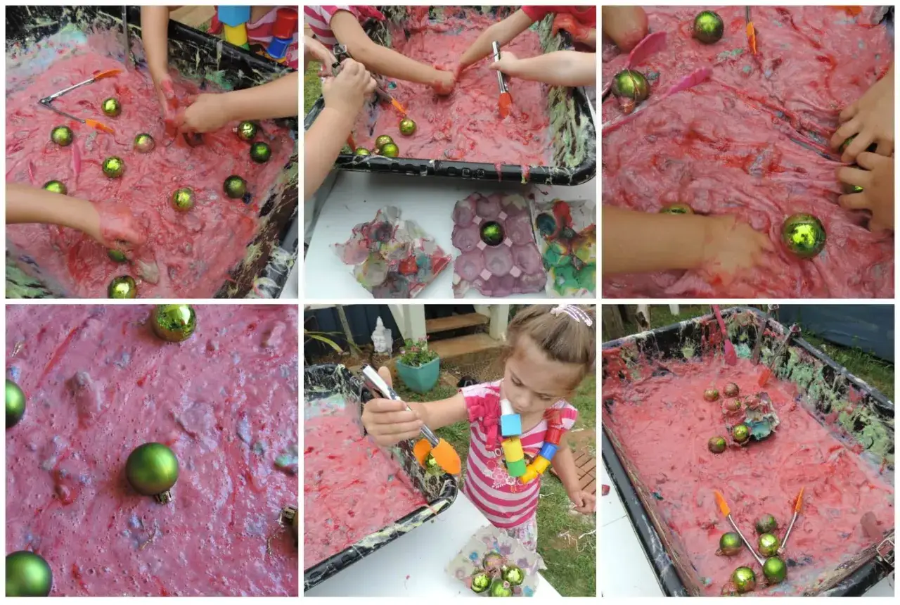 Kinder spielen mit rotem Schleim und grünen Kugeln. Die Schleim-Zutaten sind im Spielzeug-Wagen versteckt.