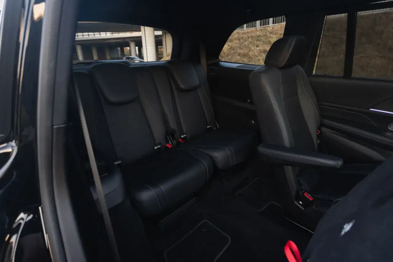 Wnętrze luksusowego Mercedesa Benz GLS z czarną, skórzaną tapicerką. Widoczne wygodne fotele i dużo miejsca.