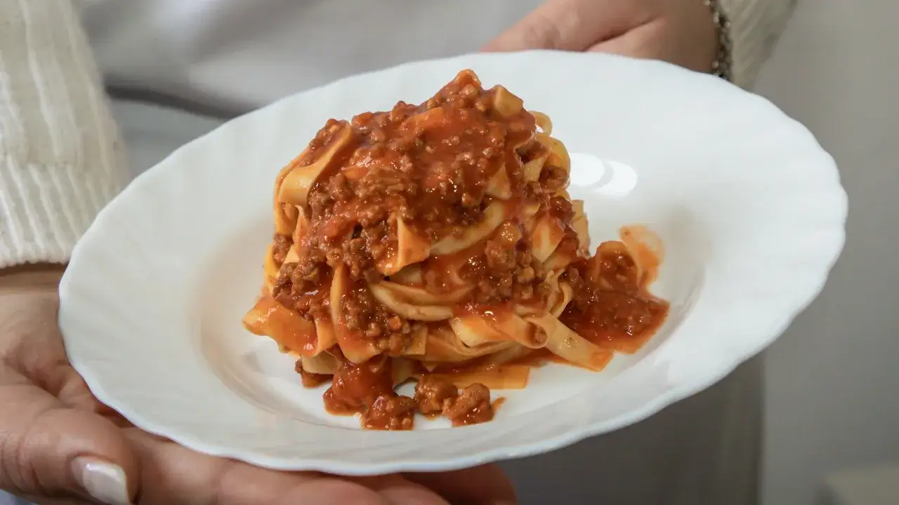 Une assiette de p&acirc;tes tagliatelles g&eacute;n&eacute;reusement napp&eacute;es d'une sauce bolognaise maison, pr&ecirc;te &agrave; &ecirc;tre d&eacute;gust&eacute;e.