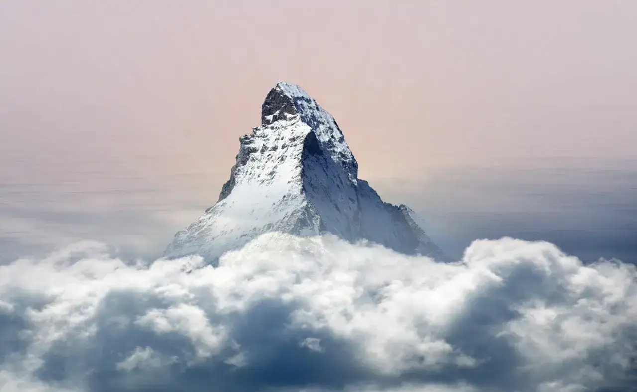 Majest&auml;tisches Matterhorn Nordwand ragt aus Wolken empor, ein eisiger Gigant im sanften Licht des Himmels.