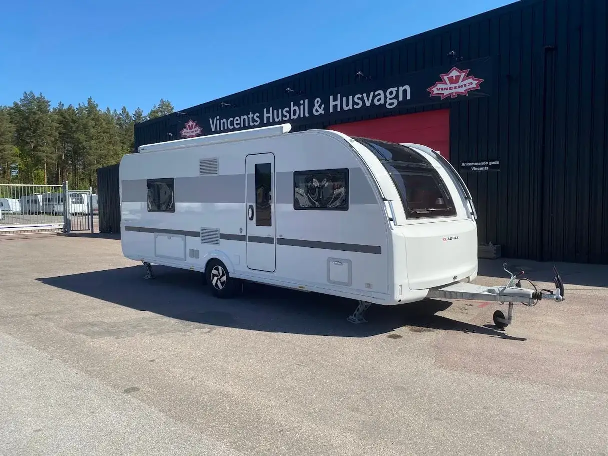 Vit Adria Alpina 613 UT husvagn st&aring;r parkerad framf&ouml;r Vincents Husbil & Husvagn.