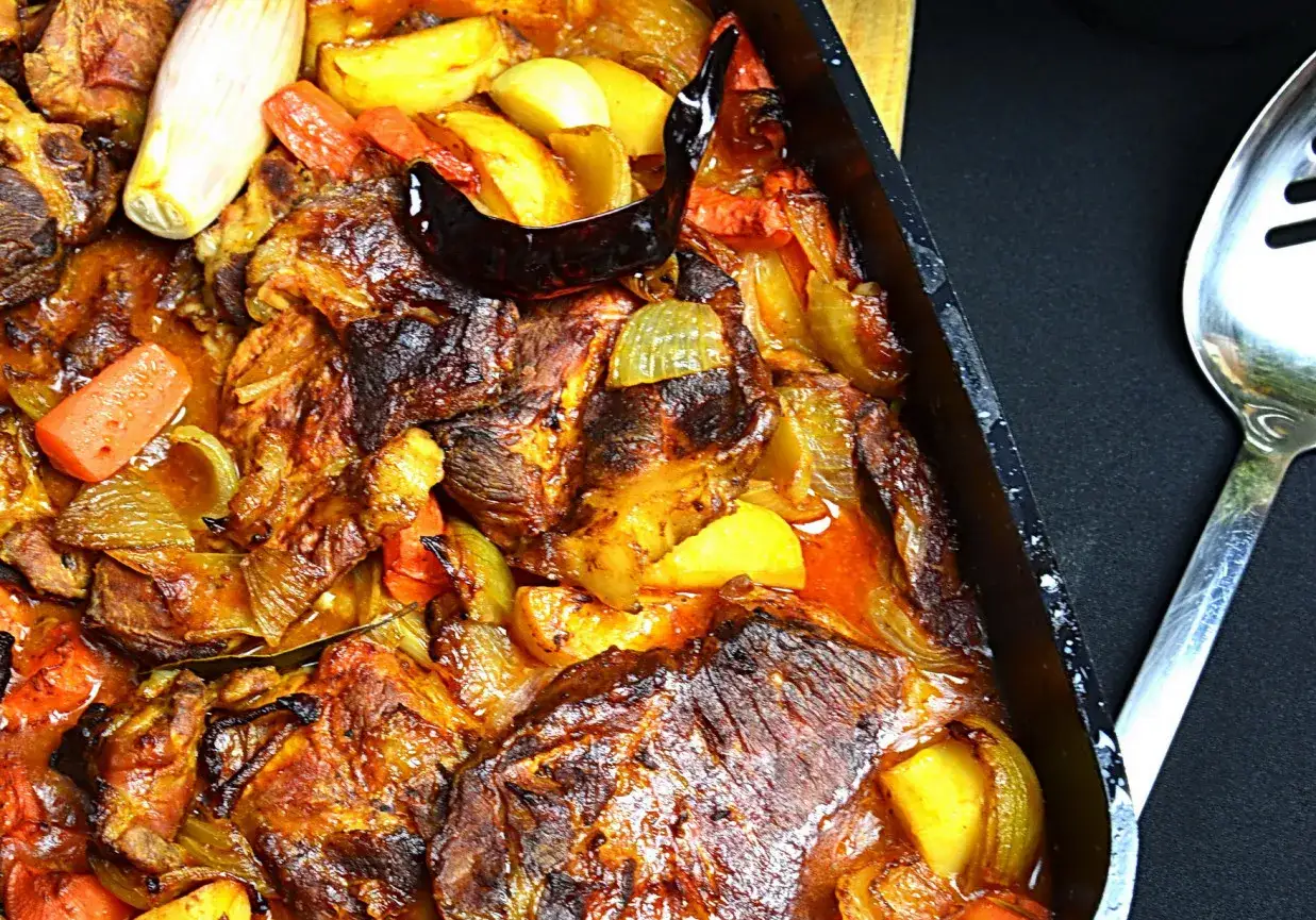Miękka karkówka z piekarnika z warzywami, pieczona do perfekcji. Aromatyczne kawałki mięsa otulone soczystymi warzywami, gotowe do podania.