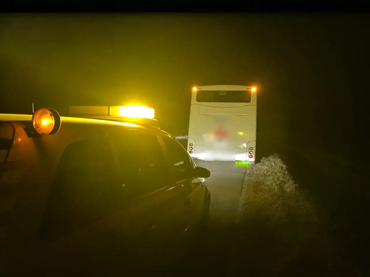 Nocna pomoc drogowa PZU. Pomoc techniczna przy autobusie na poboczu drogi, oświetlonym żółtym światłem.