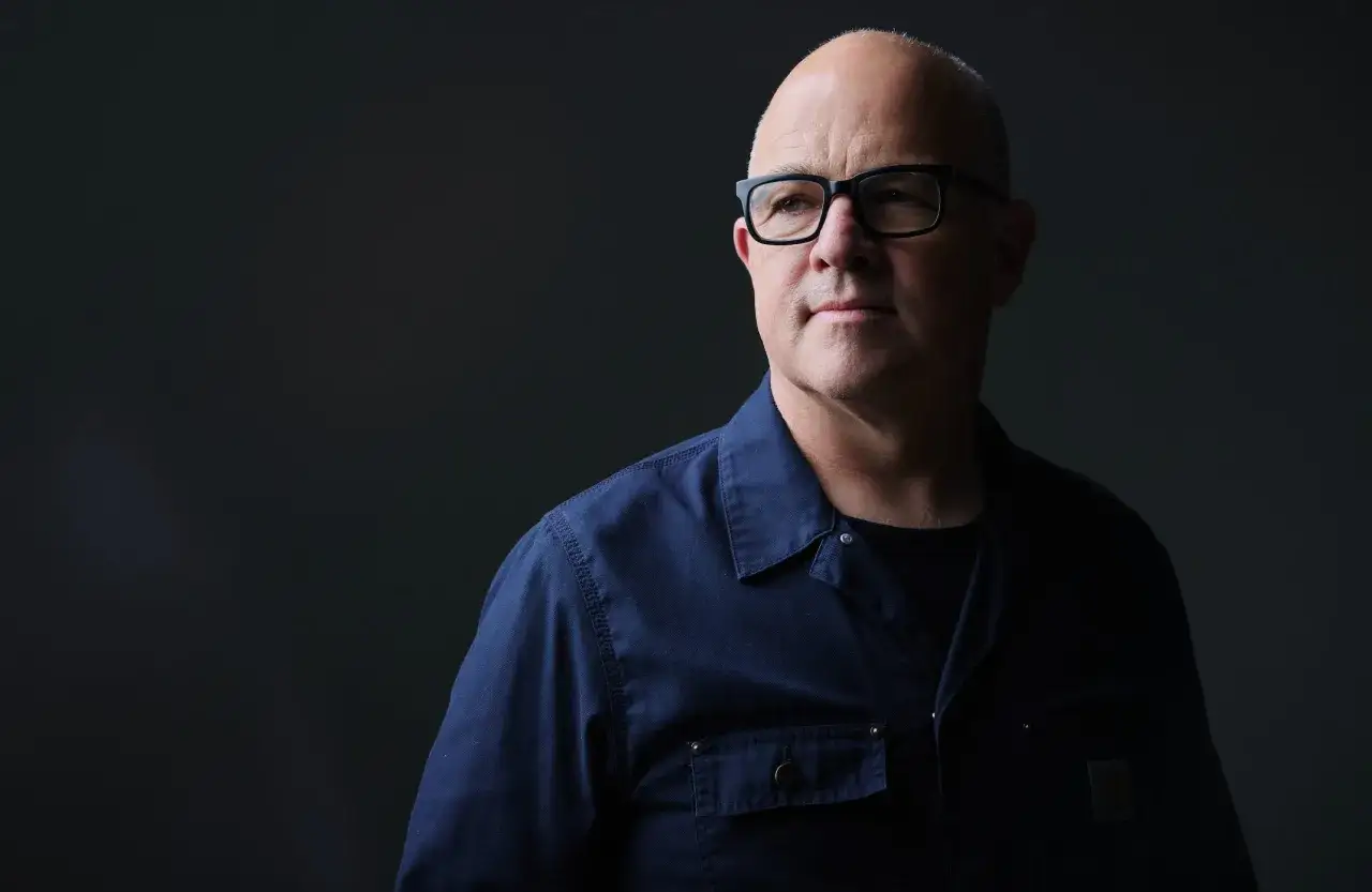 A bald man with glasses in a blue shirt ponders if an MPA is worth it.