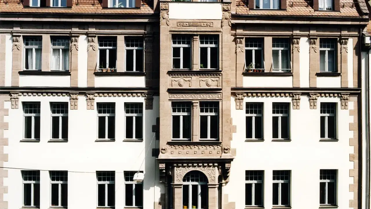 Fassade eines Altbaus mit vielen Fenstern. Hier k&ouml;nnte eine energetische Sanierung Beratung ansetzen, um die Effizienz zu steigern.