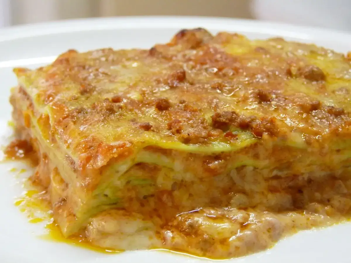 Une part de lasagne, riche en couches de pâtes, sauce bolognaise et béchamel, évoque la **lasagne origine** italienne.
