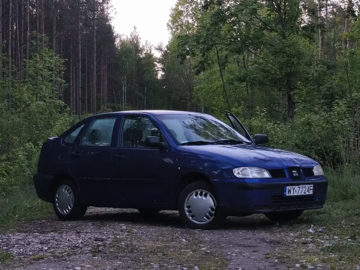 Niebieski Seat Cordoba stoi na leśnej drodze.