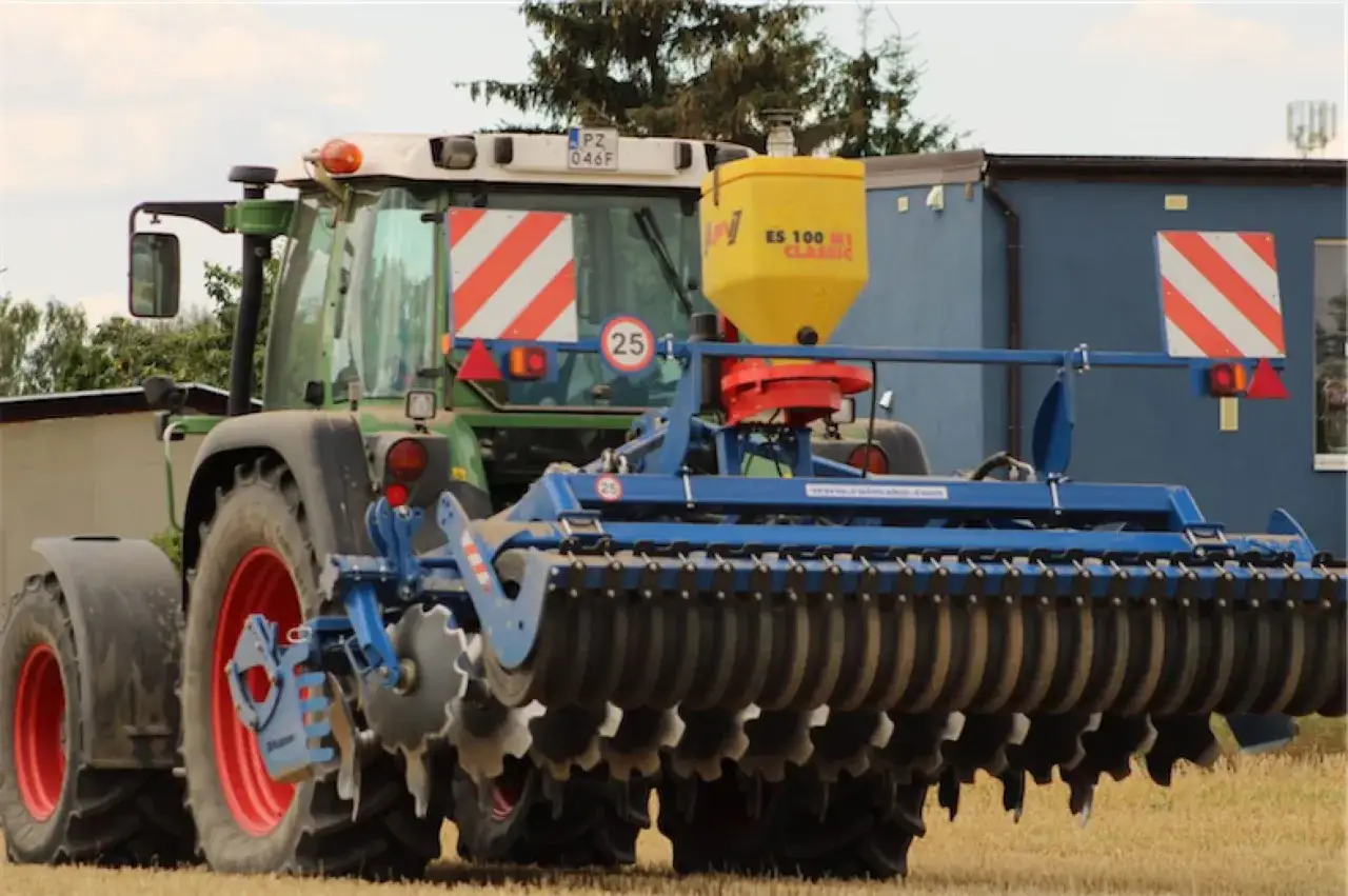 Tracteur vert avec semoir jaune et outil de travail du sol, prêt pour la culture sans labour.