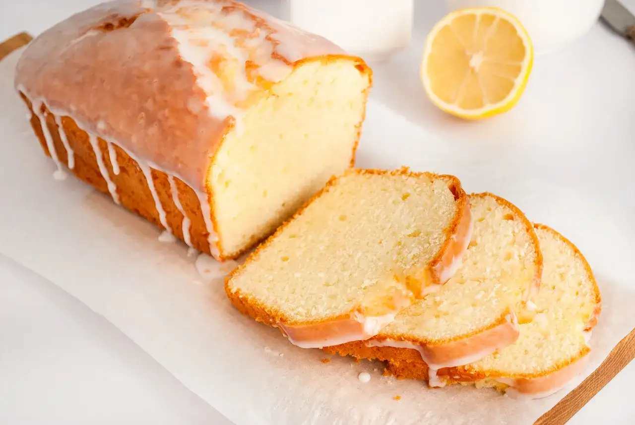 Najbardziej wilgotna babka cytrynowa, oblana lukrem, z kilkoma plasterkami obok.