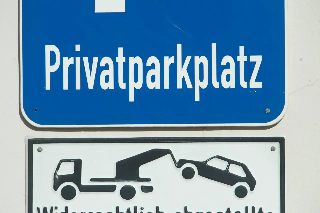 Privatparkplatz-Schild mit Abschleppwagen-Symbol. Wer falsch parkt, zahlt den Abschleppdienst.