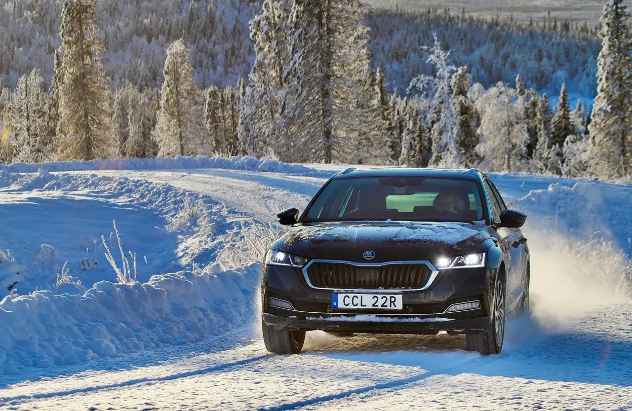 Skoda Octavia IV problem: bilen kör på en snöig väg i Sverige, omgiven av frostiga träd.