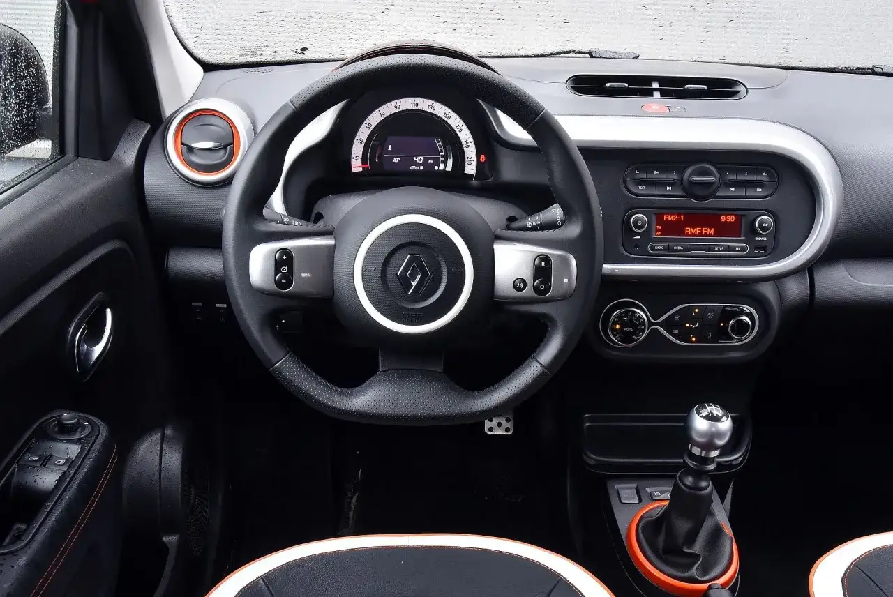 Wnętrze renault twingo 3: kierownica, cyfrowy wyświetlacz, radio i dźwignia zmiany biegów.