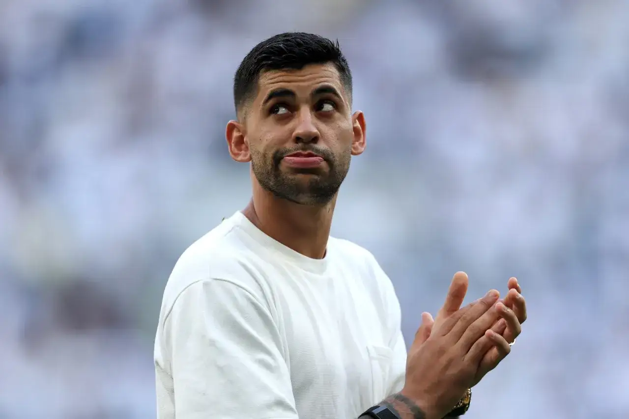 Cristian Romero, mit einem nachdenklichen Blick und klatschenden H&auml;nden, tr&auml;gt ein wei&szlig;es T-Shirt.