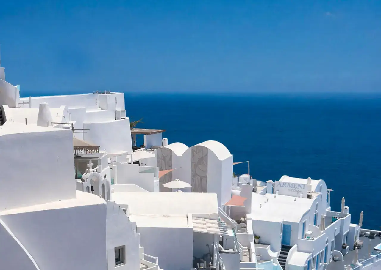 Białe domy Santorini z niebieskim morzem w tle. Czy warto tu przyjechać? Tak, widoki zapierają dech!
