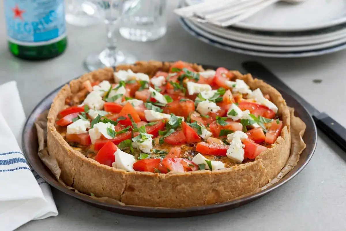 En härlig italiensk paj med tomater, mozzarella och basilika. Perfekt för en lätt lunch eller middag.