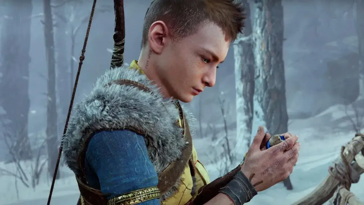 Atreus, zamyślony, trzyma w dłoni amulet. W tle zimowy las, a na plecach łuk.