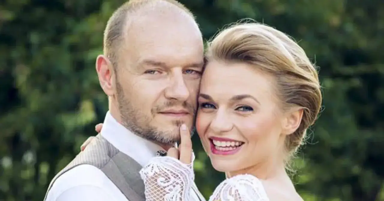 Emilia Komarnicka z pierwszym mężem, w dniu ślubu. Uśmiechnięta para na tle zieleni.