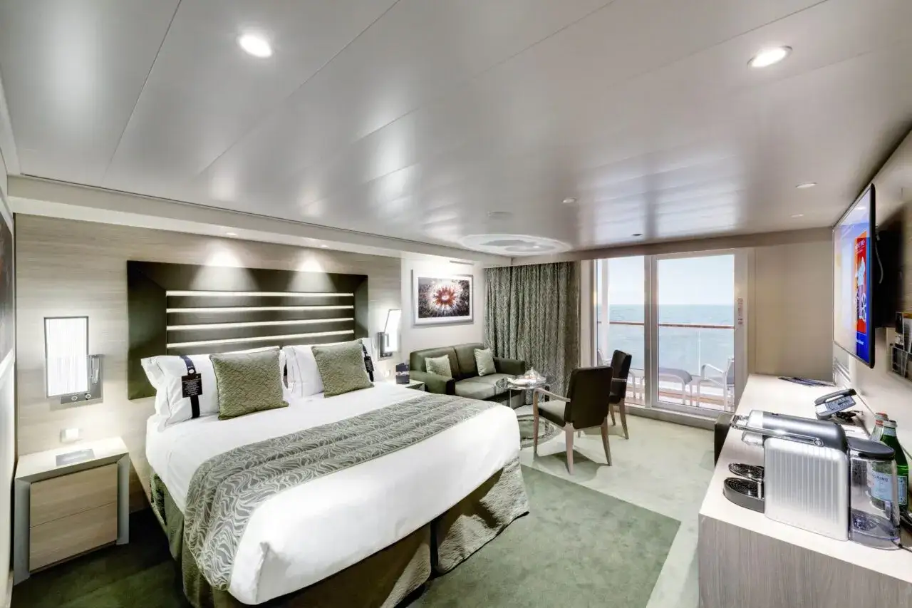 Lussuosa cabina nave con letto king-size, divano, balcone vista mare e TV.