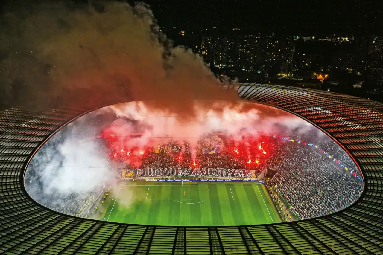 Nawrocki Lechia w dymie rac i pirotechniki. Stadion wypełniony kibicami, którzy tworzą niesamowitą atmosferę.
