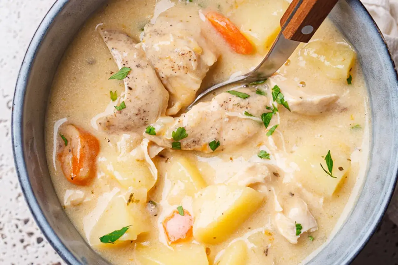 Un réconfortant blanquette de dinde avec des morceaux de dinde tendre, des pommes de terre et des carottes dans une sauce crémeuse, garni de persil frais.