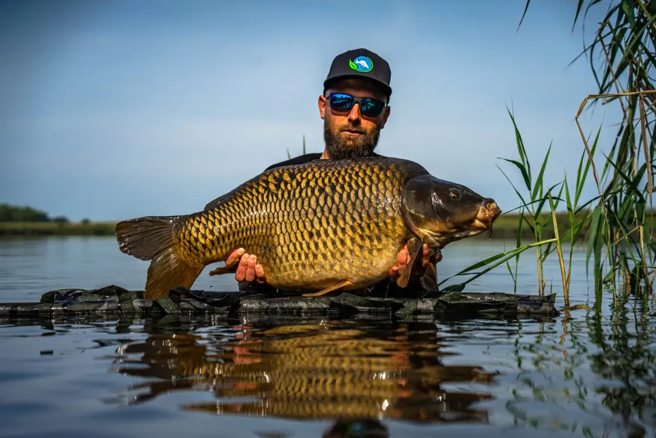 Wędkarz z okazałym karpiem na łowisku Extra Carp Radymno.