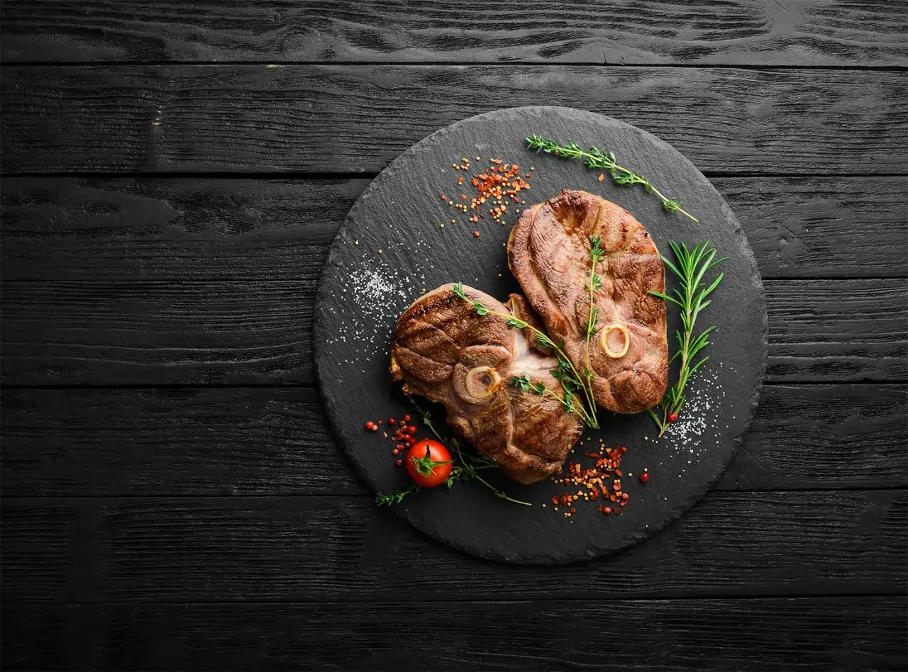 Deux tranches de gigot d'agneau au barbecue, parfaites pour un repas savoureux. Le temps de cuisson idéal pour cette viande tendre.