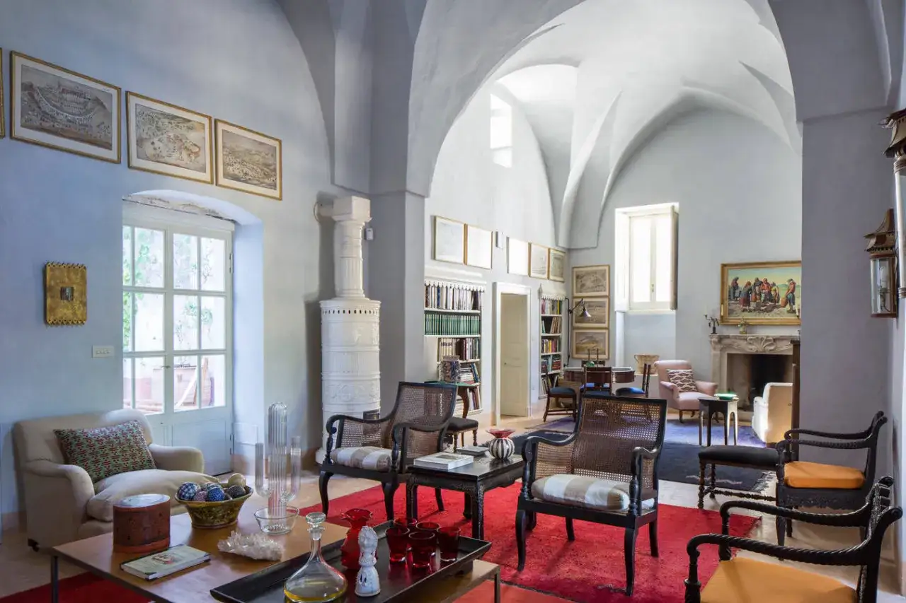 Salotto con soffitto a volta, stufa in maiolica e arredi eleganti, un esempio di case tipiche italiane.