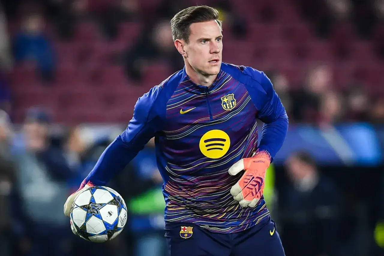 Marc-André ter Stegen, bramkarz FC Barcelony, w rękawicach i z piłką w dłoni, gotowy do akcji.