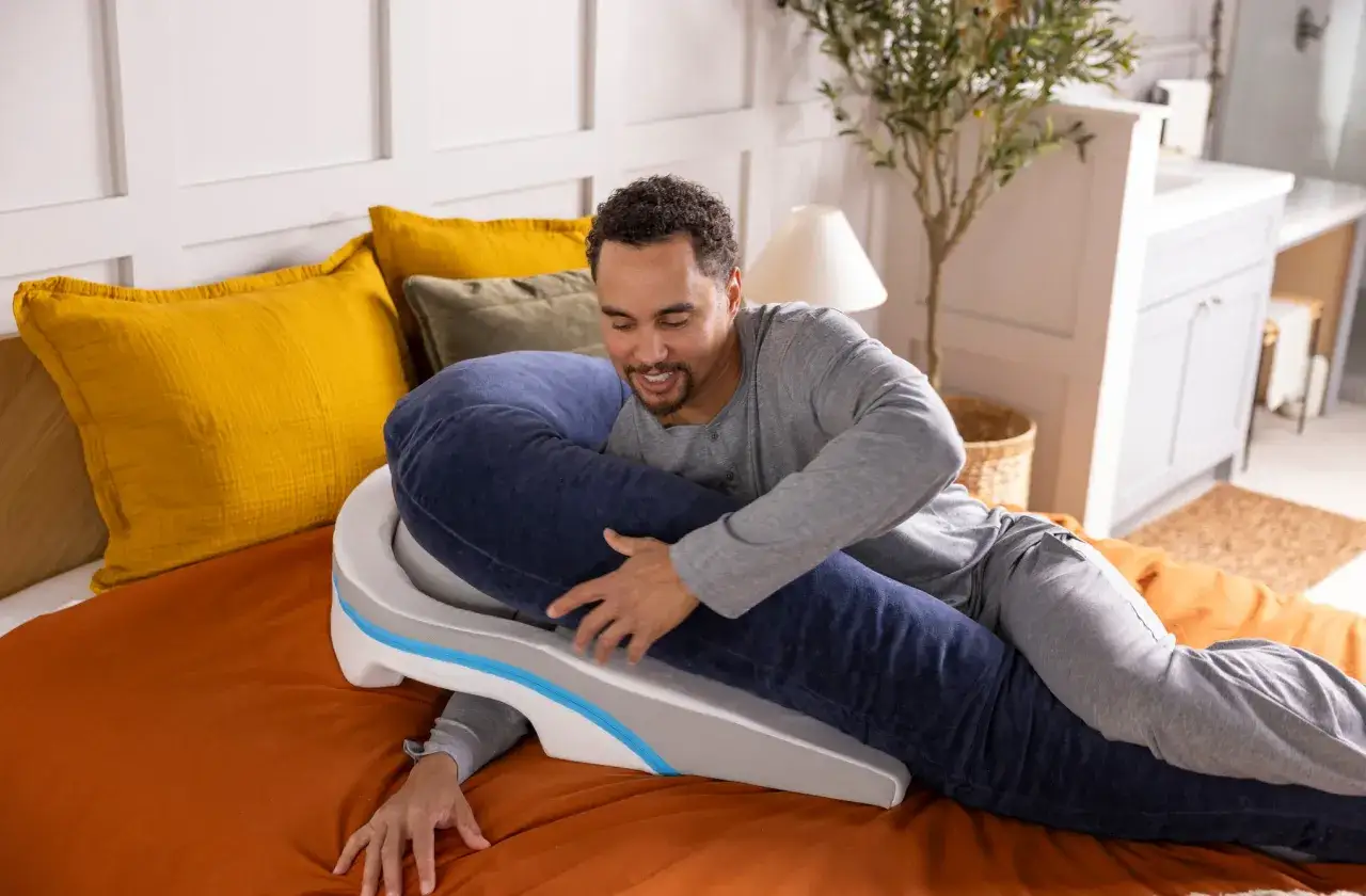 Man uses a wedge pillow to find a comfortable position, offering a solution for how to sleep with vertigo.