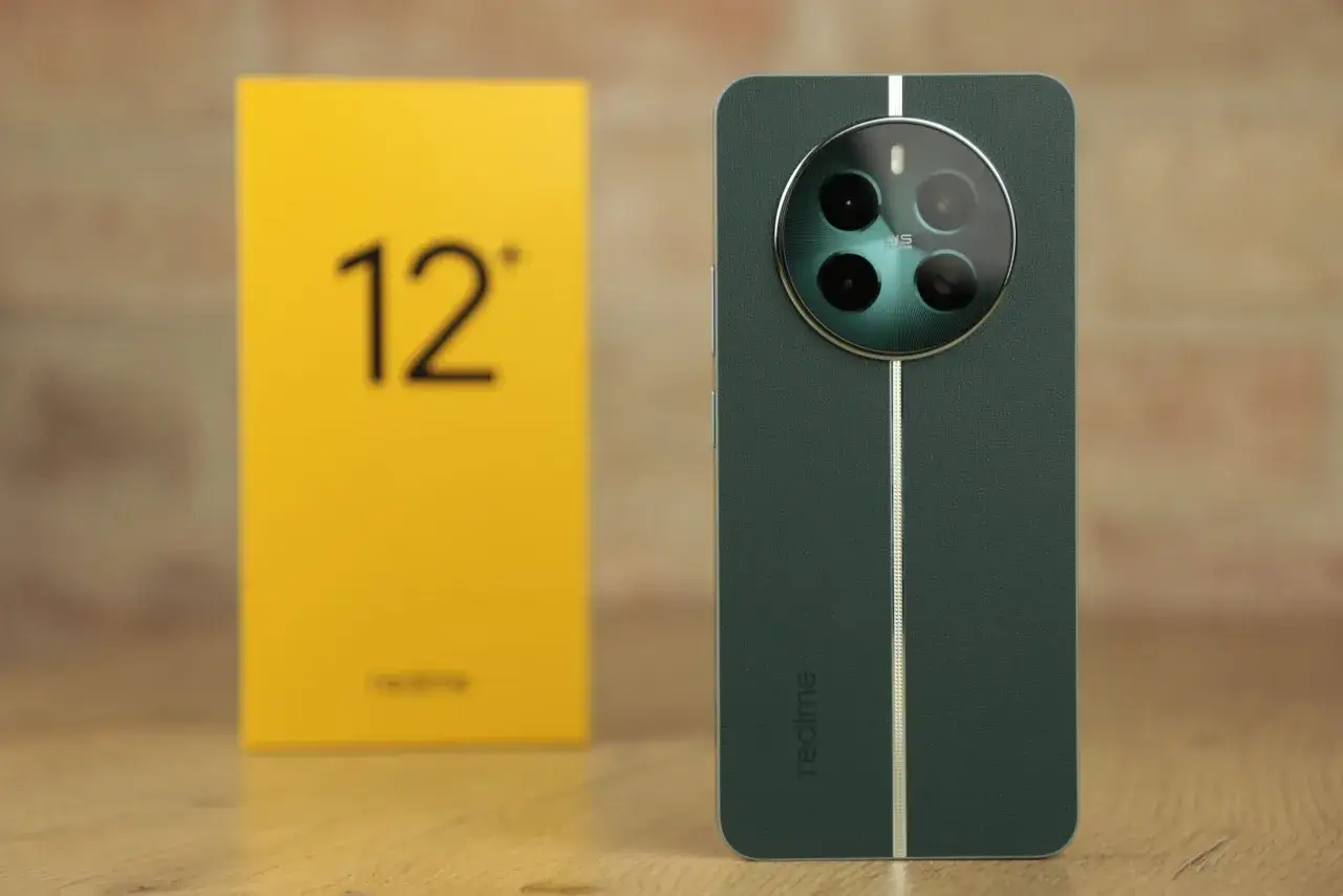 Zielony telefon realme 12 plus z okrągłą wyspą aparat&oacute;w i ż&oacute;łte pudełko z napisem 