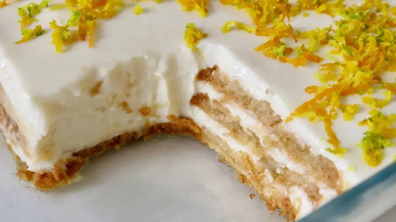 Delicioso postre de limón con leche condensada y galletas, cubierto con ralladura de cítricos.