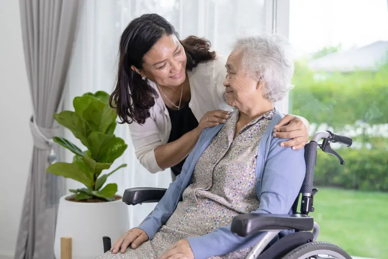 Une femme prend soin d'une personne âgée en fauteuil roulant, offrant un soutien et un réconfort. L'**apa à domicile montant** assure une présence rassurante.