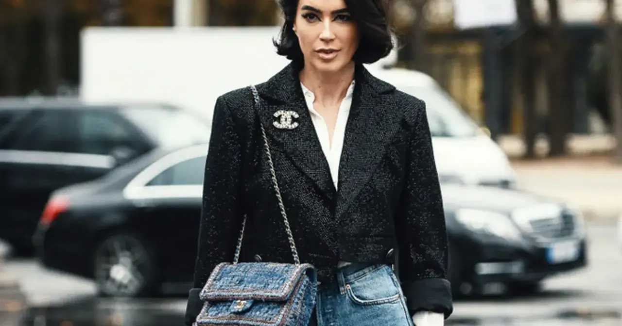 Elegancka kobieta w marynarce i jeansach, z torebką Chanel. Klasyczne coco chanel stylizacje.