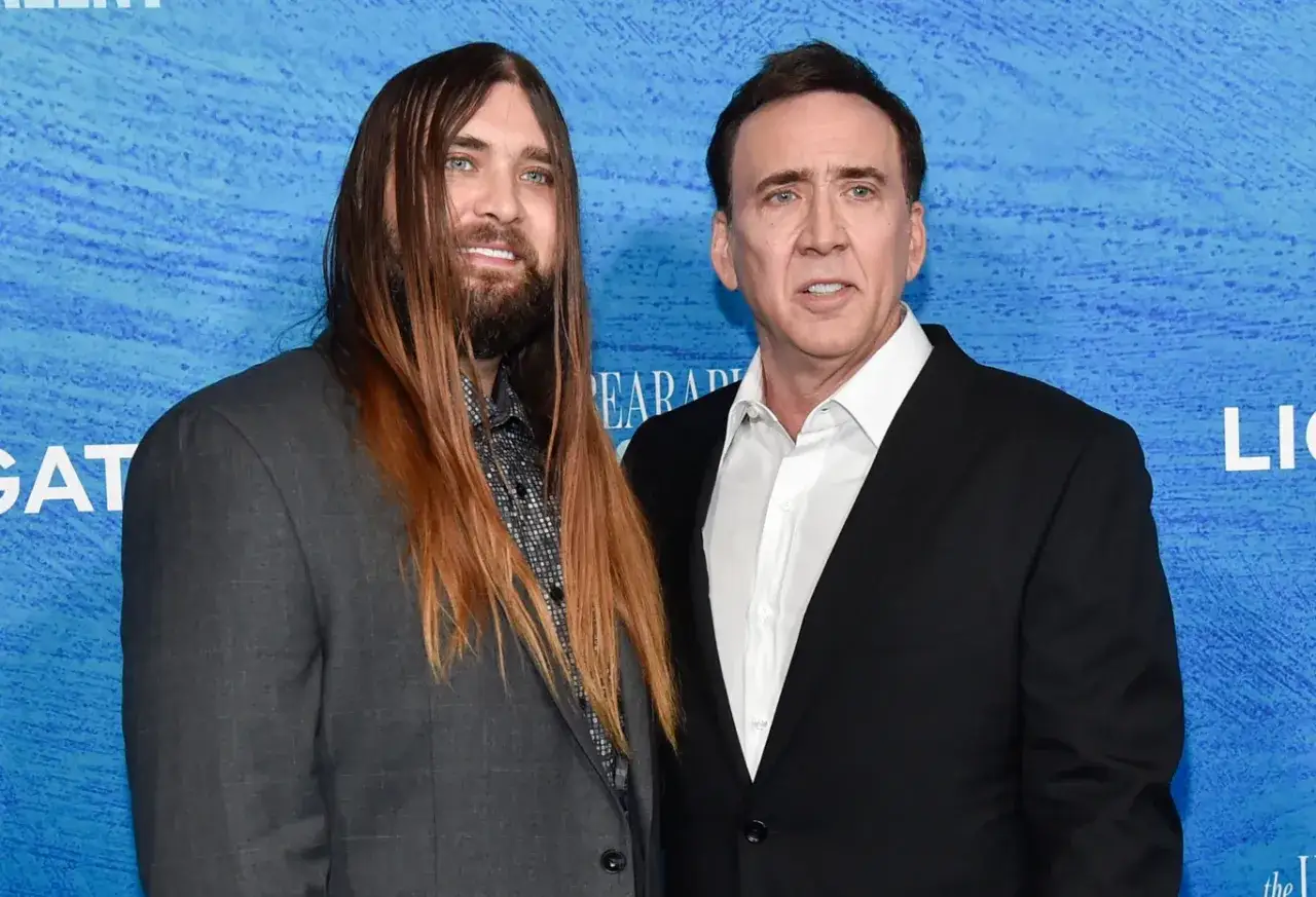Weston Coppola Cage z długimi włosami i Nicolas Cage na niebieskim tle.