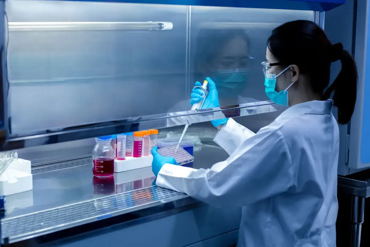 Wissenschaftlerin in Laborhaube arbeitet mit Pipette und Proben. Dies ist ein Beispiel für Forschung, die nicht mit Tierversuchen zu vergleichen ist.