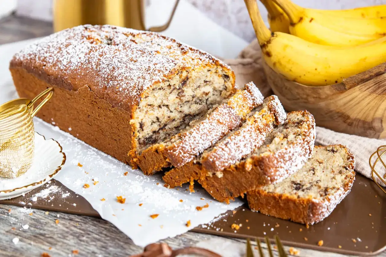 Saftiger Bananenkuchen mit Schokostückchen, bestäubt mit Puderzucker. Ein köstliches Bananenkuchen Rezept für jeden Anlass.