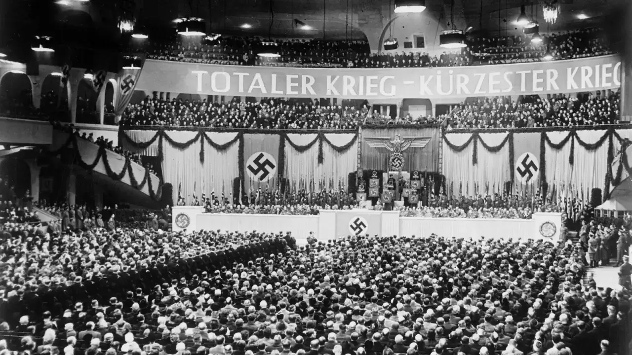 Großer Saal voller Menschen, Fahnen und Hakenkreuze. Die **Sportpalastrede**-Analyse zeigt die Propaganda des