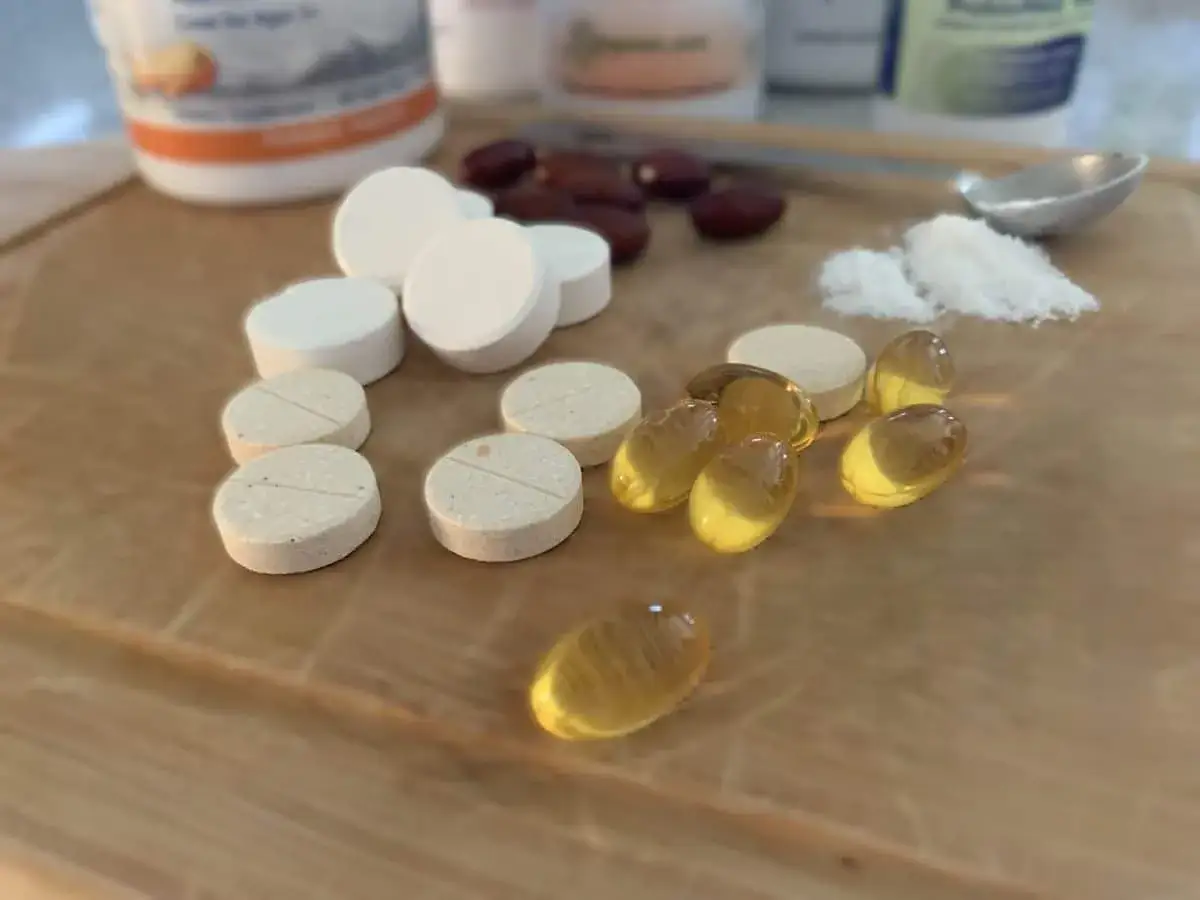 Verschiedene Pillen und Kapseln liegen auf einem Holzbrett. Eine gute Kombination ist, magnesium und vitamin d zusammen einzunehmen.