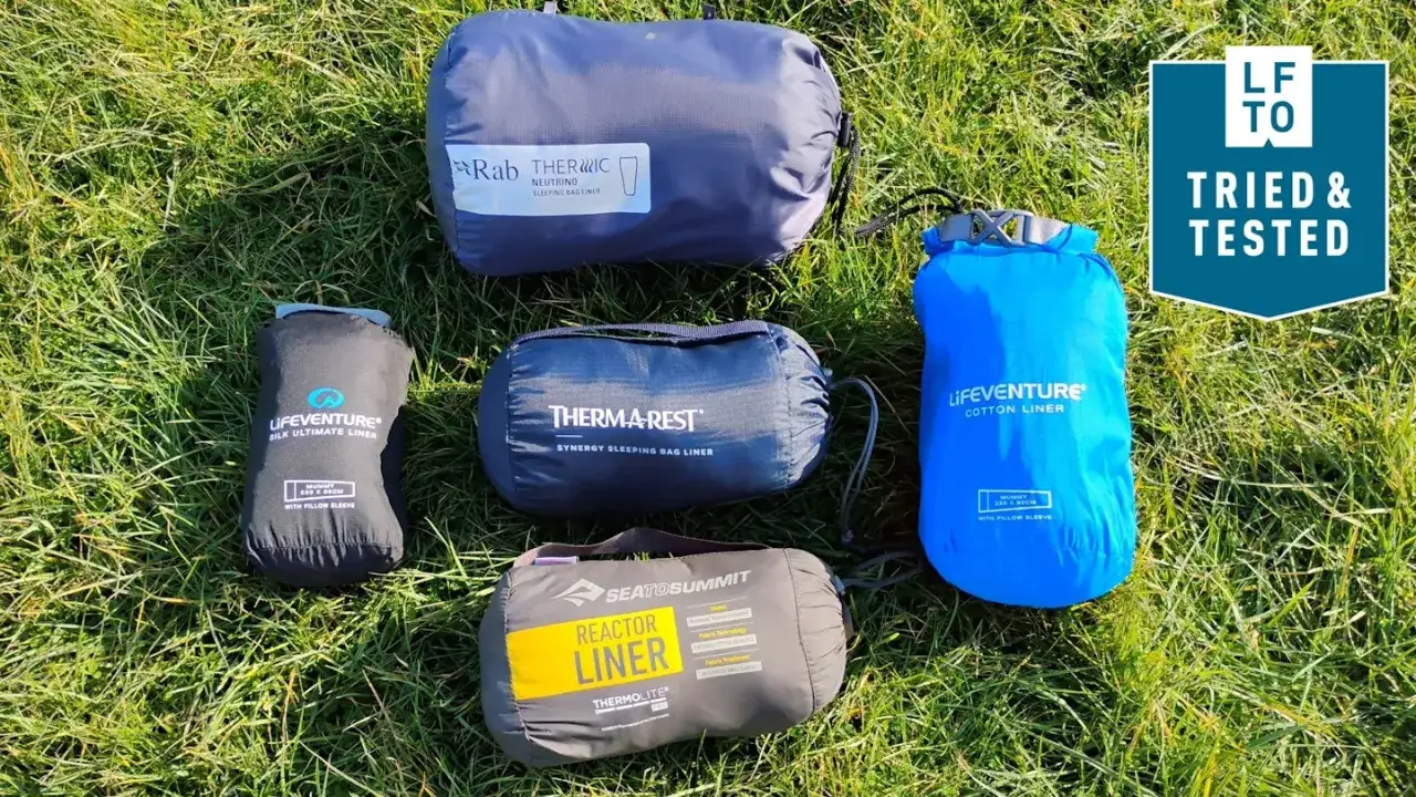 F&uuml;nf verschiedene Schlafsack-Inletts von Rab, Therm-a-Rest, Sea to Summit und Lifeventure liegen im Gras. Ein 