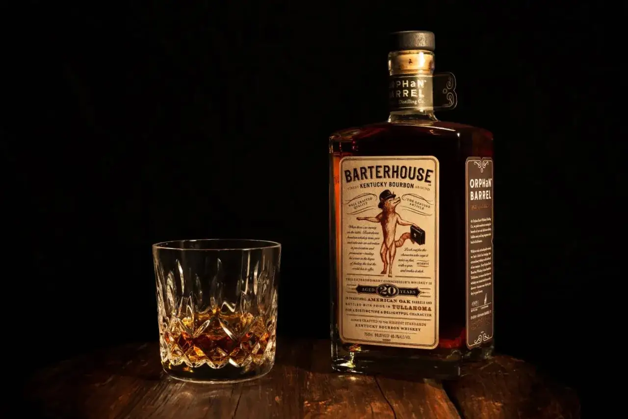 Butelka i szklanka z bursztynowym płynem. Poznaj różnicę między whisky a whiskey oraz bourbonem a scotchem.