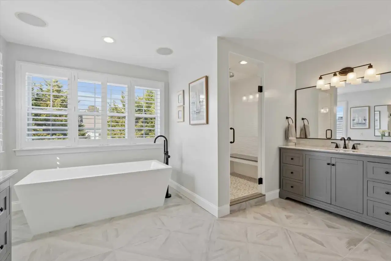 Spacious bathroom with a freestanding tub, glass-enclosed shower, and a long double vanity. The double vanity dimensions are generous, offering ample storage.