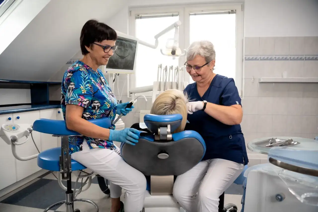 Dwie dentystki wykonują fluoryzację u pacjentki.