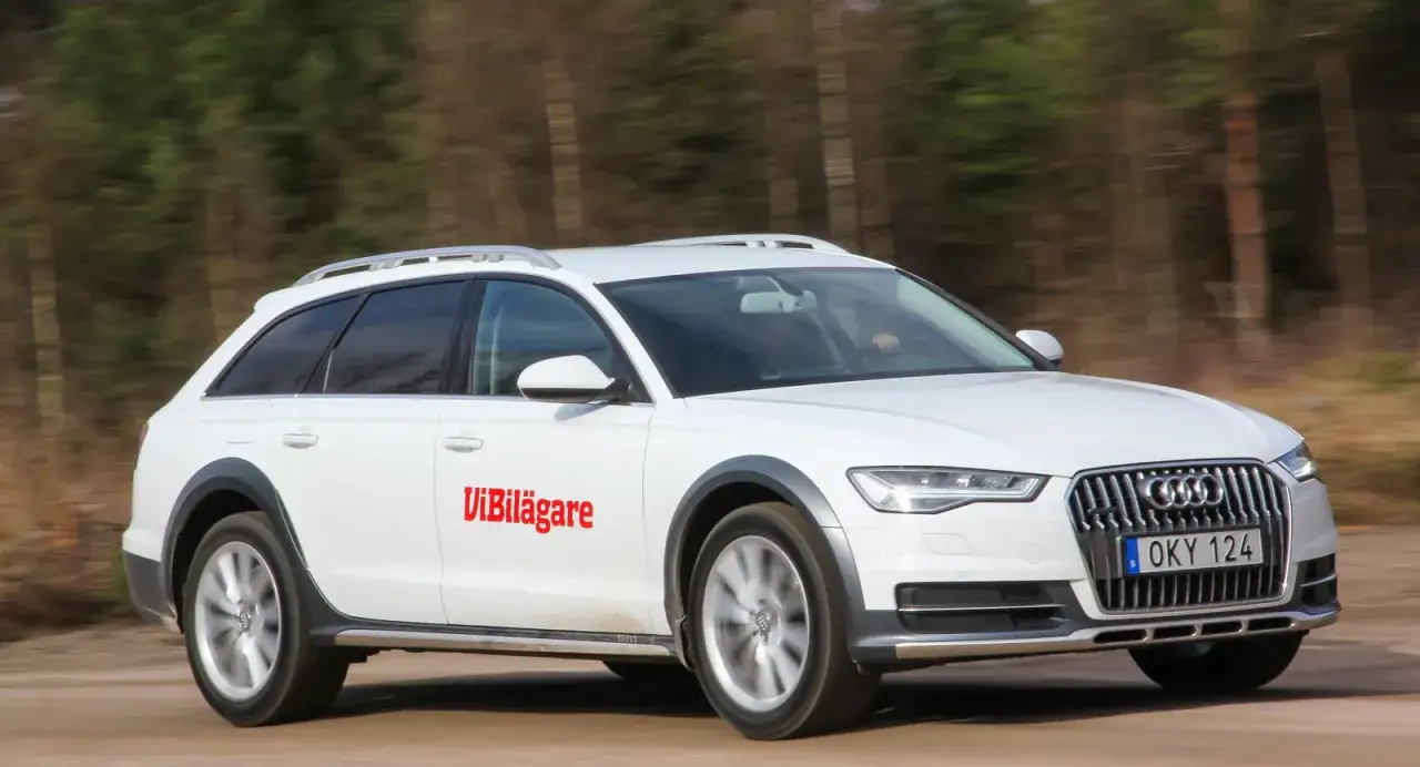 Vit Audi A6 Allroad k&ouml;r p&aring; grusv&auml;g, med texten 